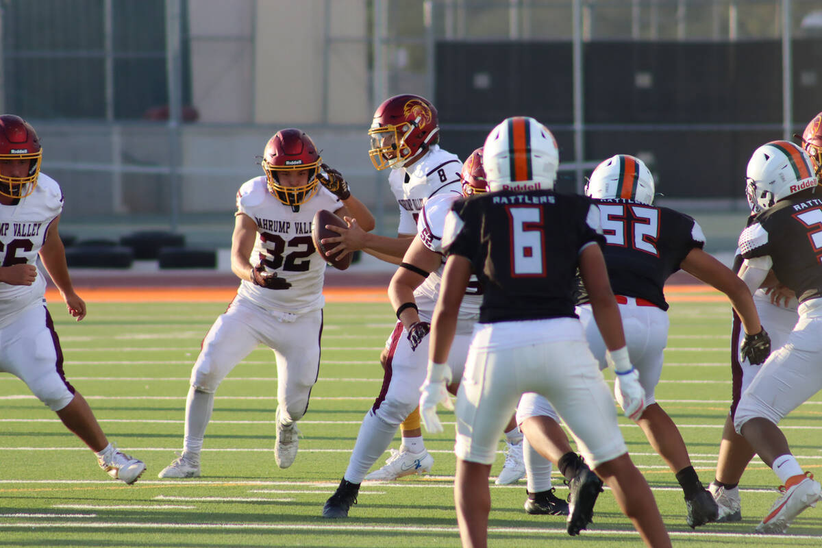 Pahrump Valley High School running back Joshua Slusher receives a hand-off from quarterback Kay ...