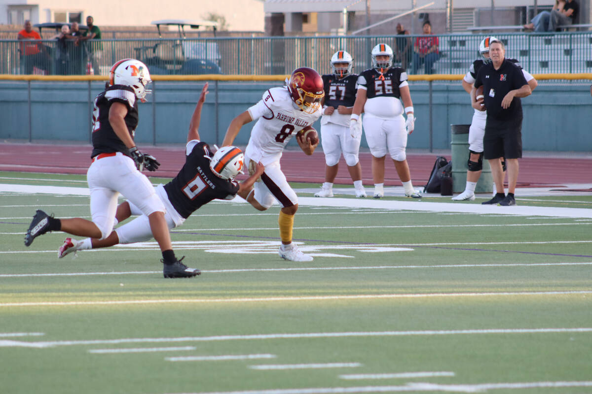 Pahrump Valley High School varsity quarterback Kayne Horibe takes off out of the pocket past an ...