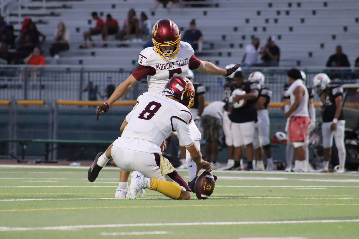 Kayne Horibe place sets the ball for kicker Aaron Rily to kick through the upright in a scrimma ...