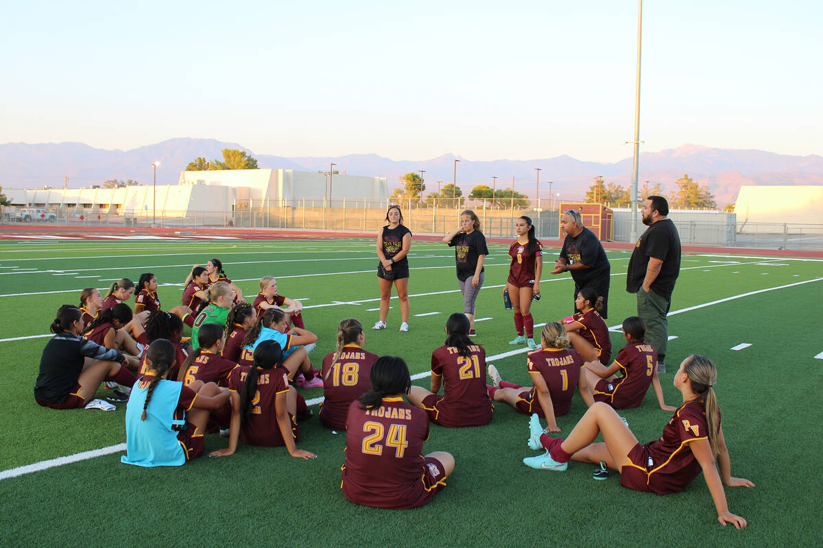 Pahrump Valley High School girls soccer assistant coach Victor Vallin consoles the team after a ...