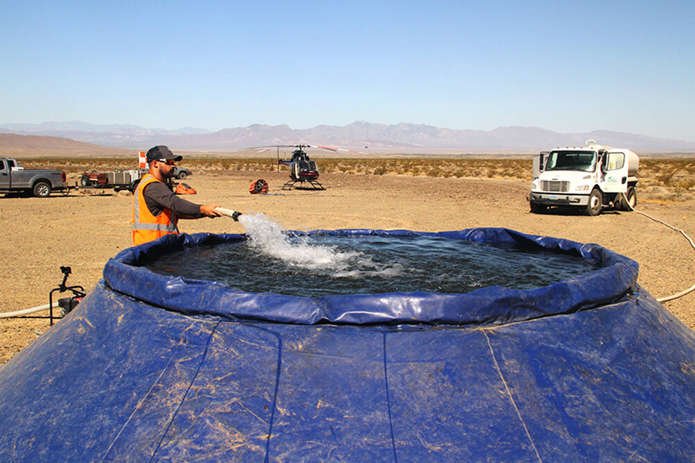 Crews with the Nevada Dept. of Conservation fill up what is known as a "pumpkin" in readiness f ...