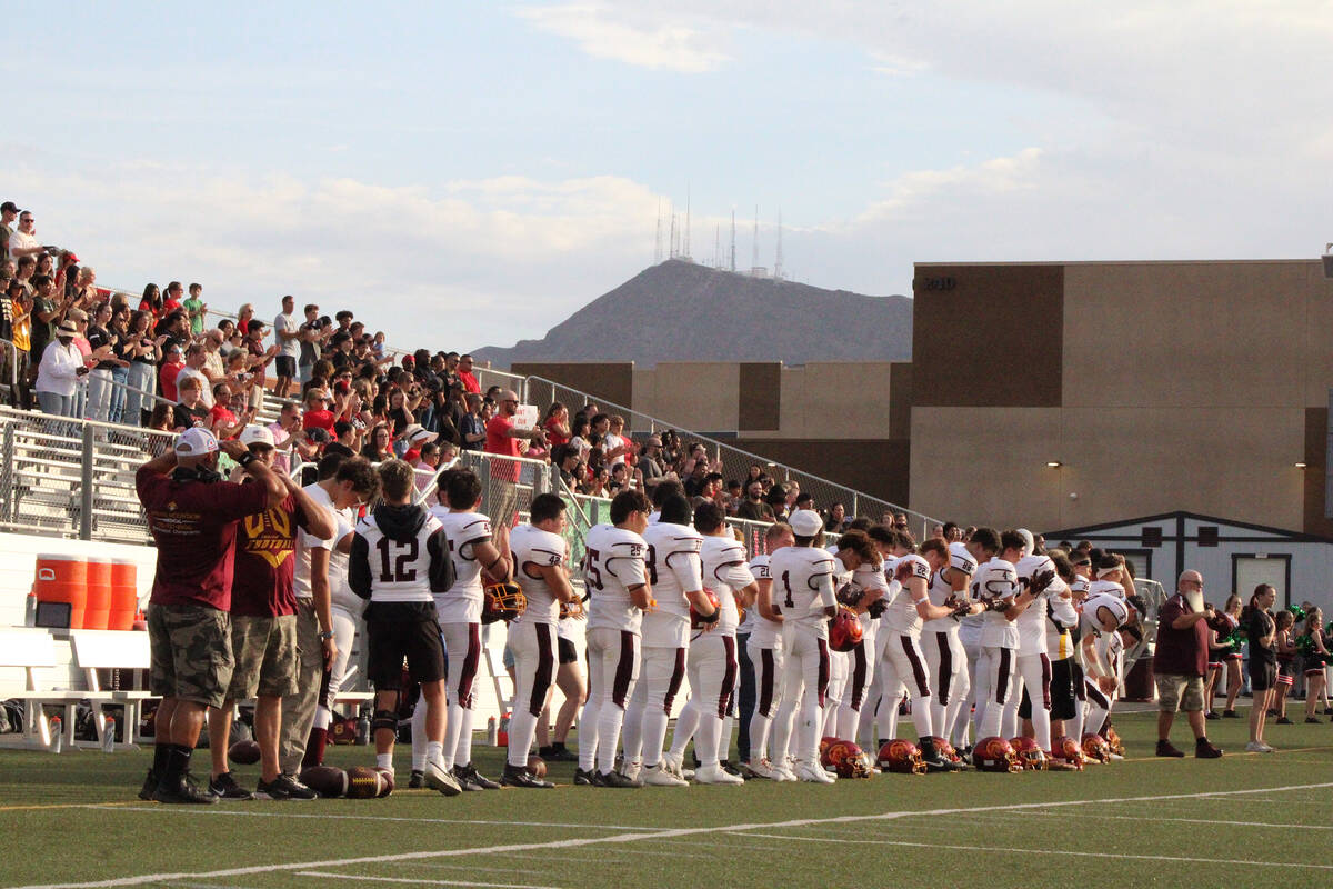 The Pahrump Valley High School football team stands for the national anthem before their away ...