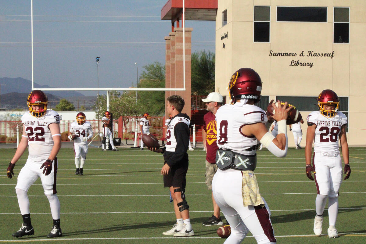 Trojans senior quarterback takes pre-game snaps from senior Jace Wulfenstein who is expected to ...