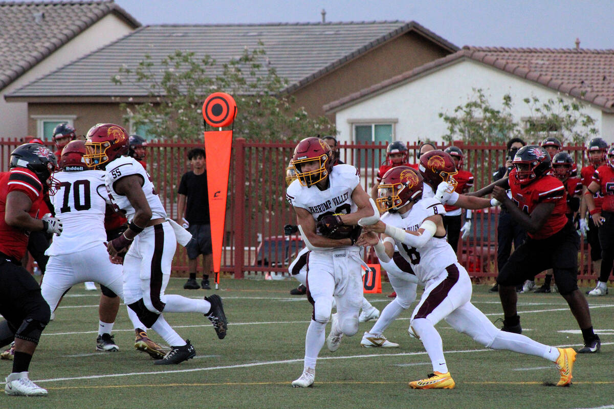Trojans senior QB Kayne Horibe hands the ball off to senior RB Austin Alvarez against Pinecrest ...