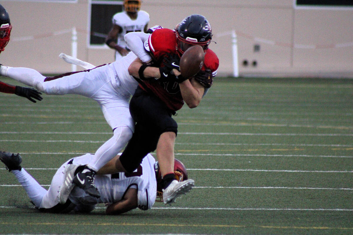 Trojans junior Ryan Hamlin punches the ball out from the Cougars to stop them from scoring in t ...