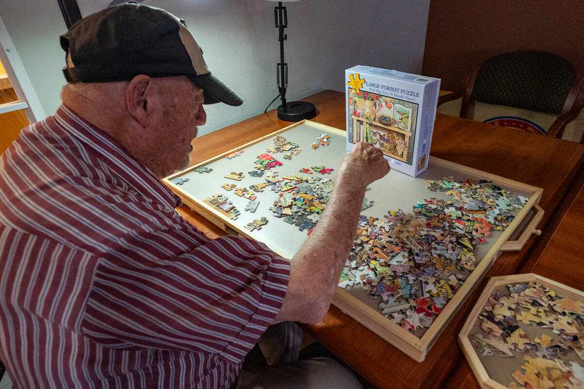 Resident Rodger Lyman works on a puzzle in the property's movie room. (John Clausen/Pahrump Val ...