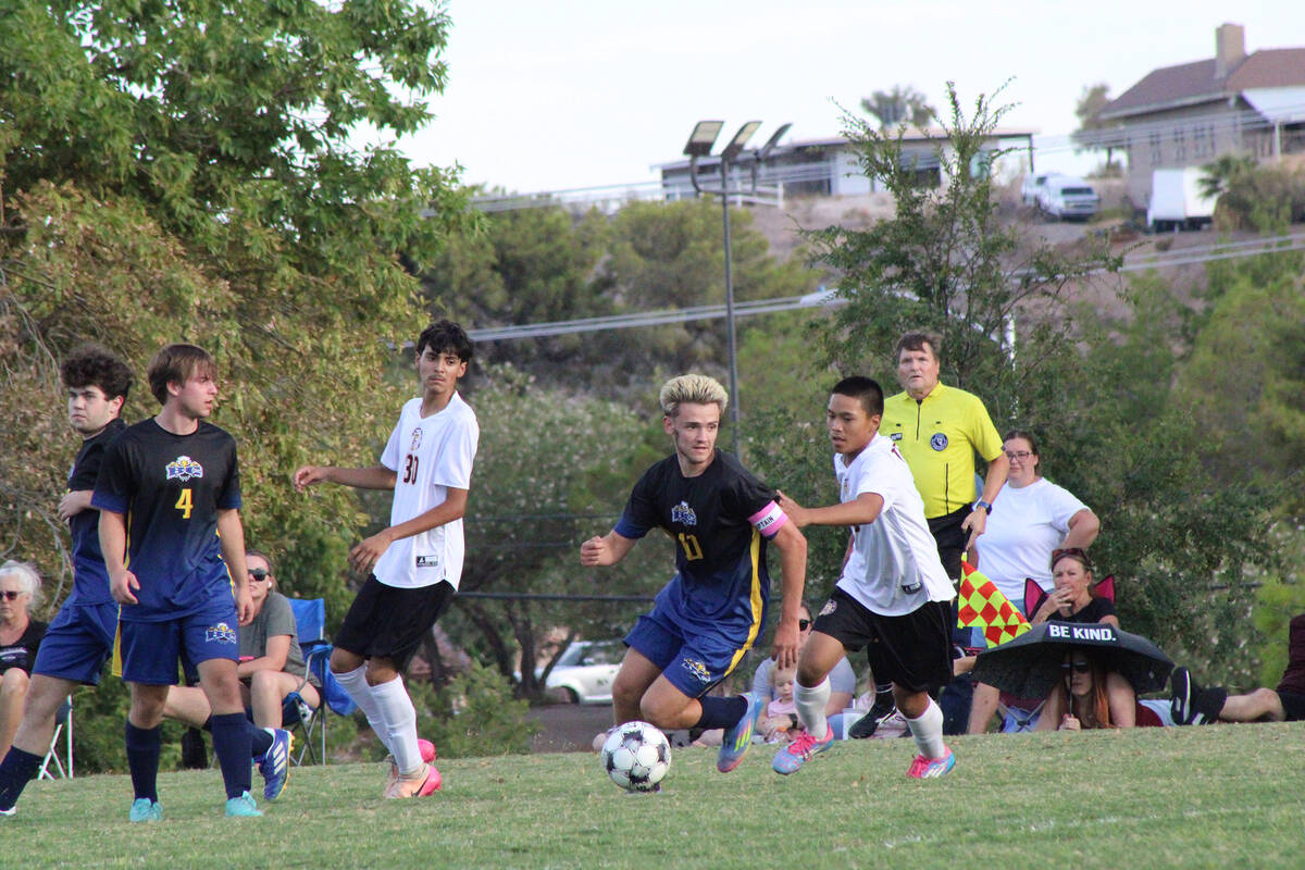 Trojans sophomore midfielder Randall Pangilinan attempts to steal the ball away from a Boulder ...