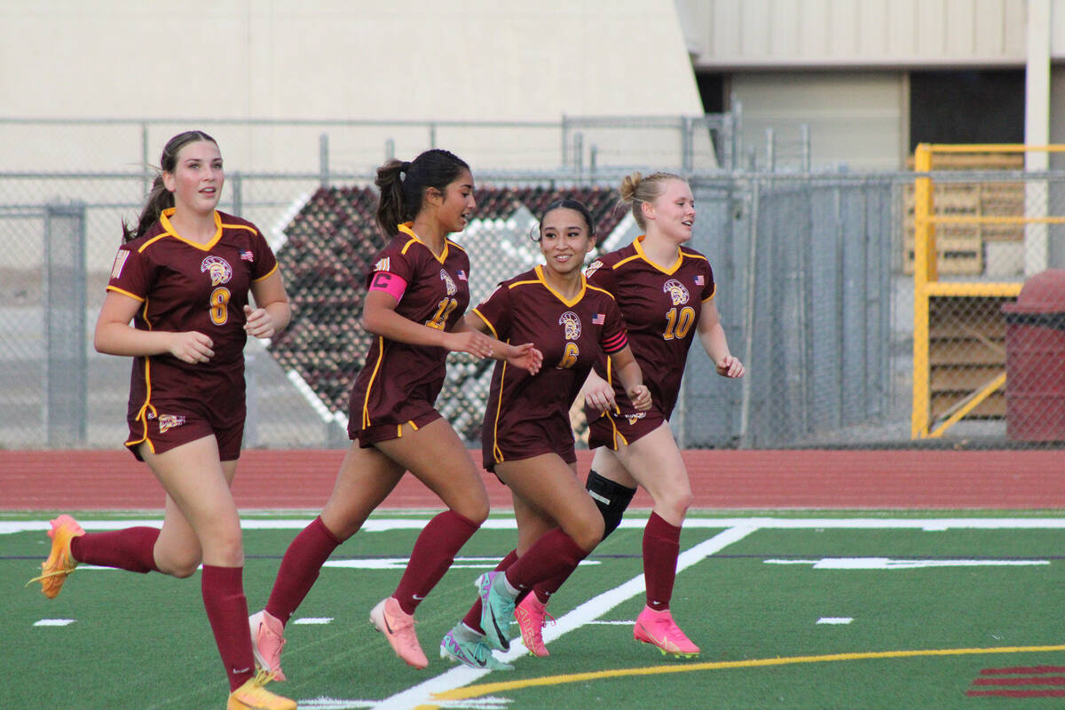 The Pahrump Valley High School Trojans girls soccer team celebrates following a goal by Natalie ...