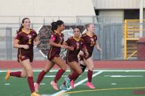 The Pahrump Valley High School Trojans girls soccer team celebrates following a goal by Natalie ...