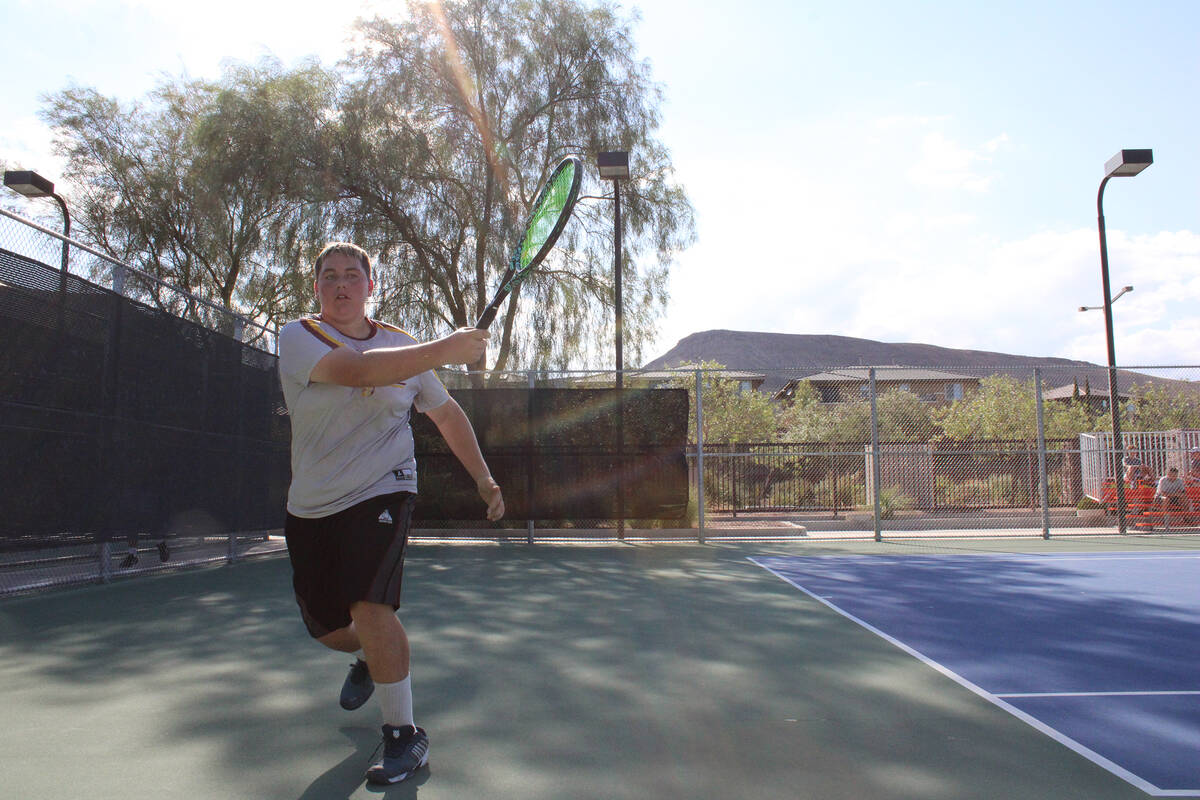 Pahrump Valley High School tennis player Lucas Johnson makes an incredible return while streaki ...
