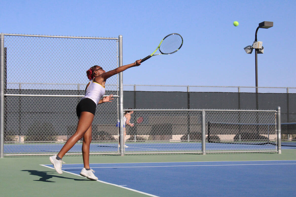 Pahrump Valley High School tennis junior Chanel Anthony delivers a serve to her opponent in a m ...