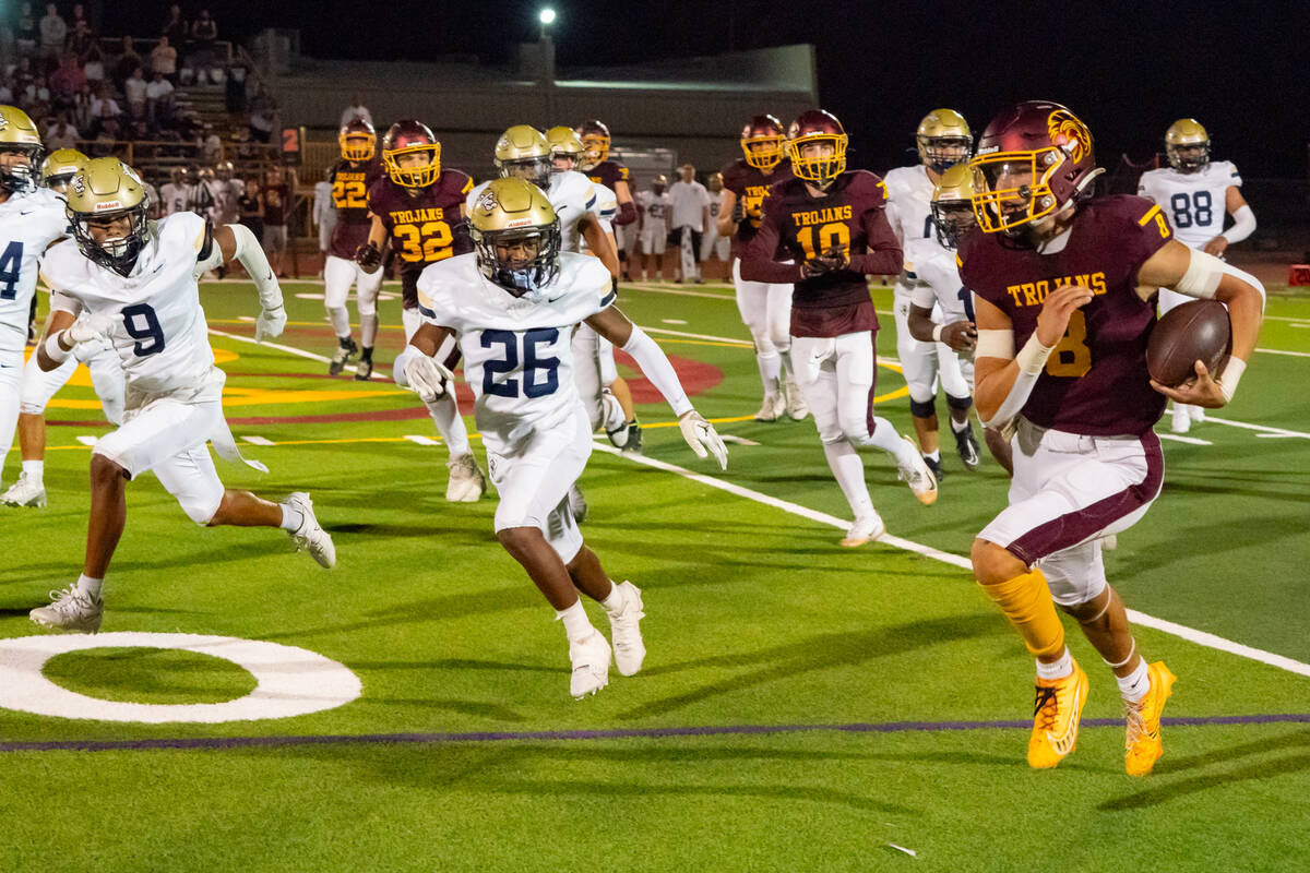 Pahrump Valley High School senior QB Kayne Horibe rushes past Spring Valley High School junior ...