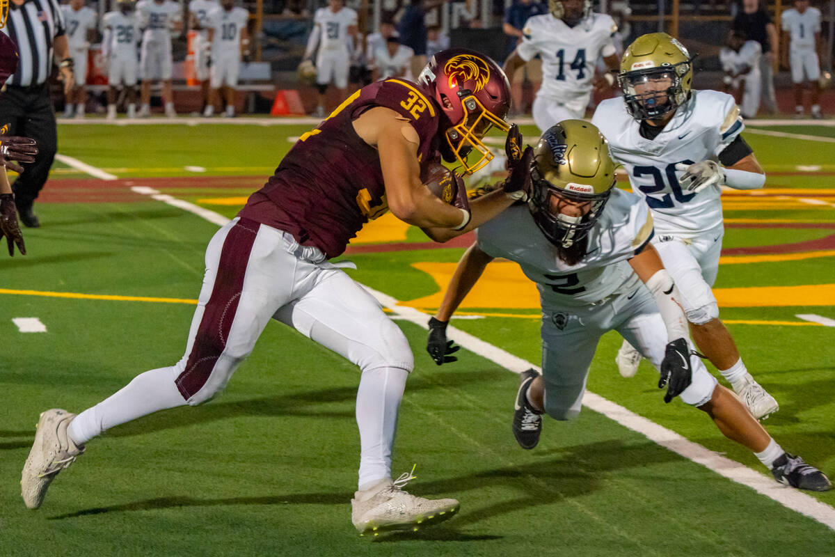 Pahrump Valley High School senior RB/LB/K Joshua Slusher pushes his way past a Spring Valley Hi ...