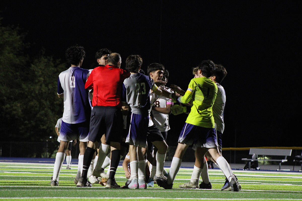 Pahrump Valley High School junior midfielder Ryan Nunez Manzo tries to hold back his teammate s ...