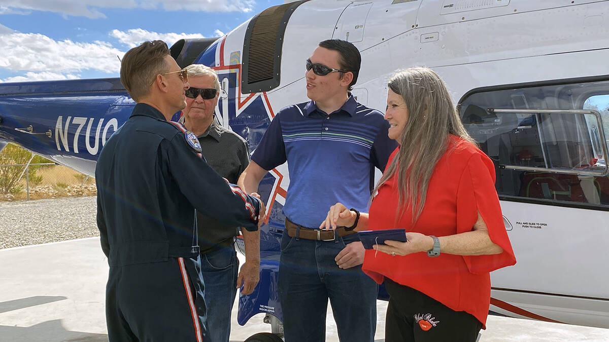 Gregory Herl's son, Jesse James, shakes hands with Mercy Air pilot Kyle Davis as he is presente ...