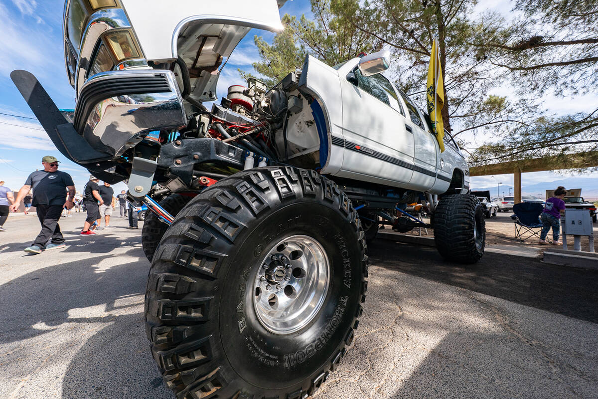 A lifted truck sits with its hood open to display its impressive engine during the Roses Show a ...