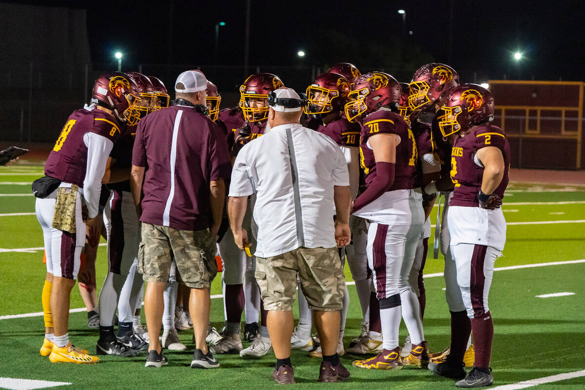 PVHS offensive coordinator Toby Henry and head coach Thom Walker talk to the offense before the ...