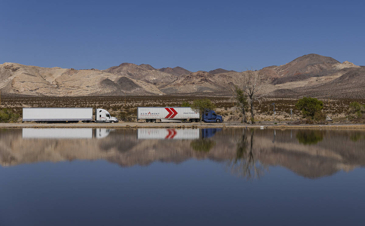 Trucks passing through Beatty are reflected in a manmade pond on land owned by Ed Ringle, which ...