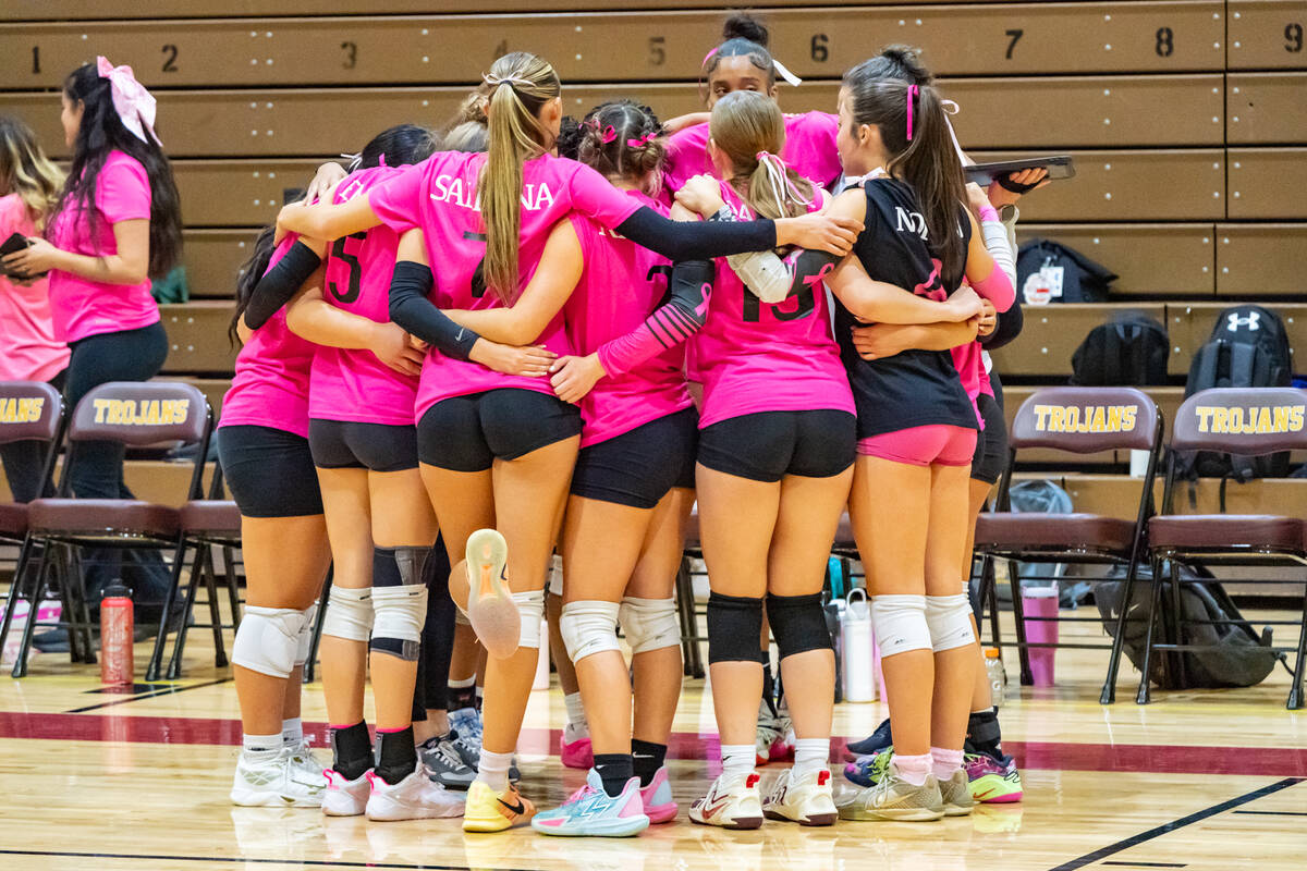 The Trojans volleyball team gathers for a quick huddle before heading back onto the court to ta ...