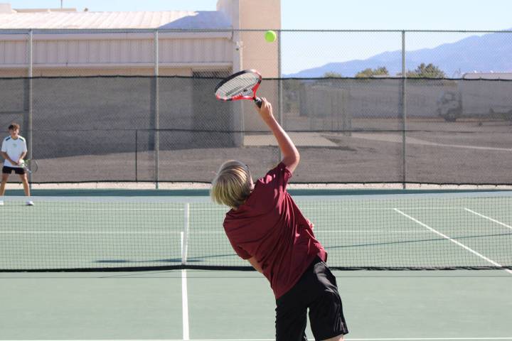Pahrump Valley High School tennis player Bryce Dykstra serves to his opponent during his single ...