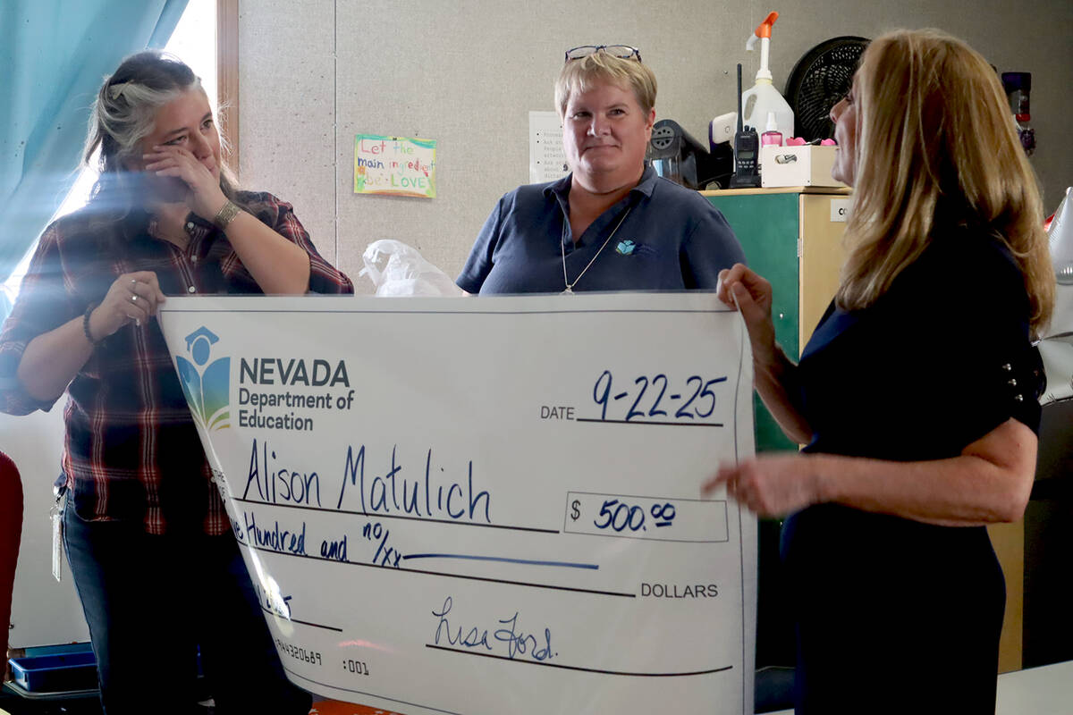 Wiping away tears of happiness, Pahrump preschool teacher Alison Matulich receives a $500 check ...