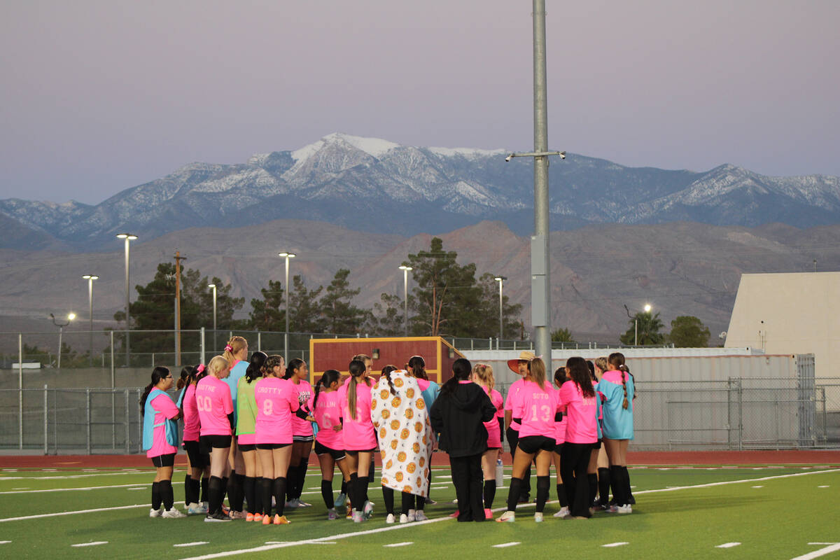 The PVHS girls soccer team huddles for warmth together during a chilly fall evening at home aga ...