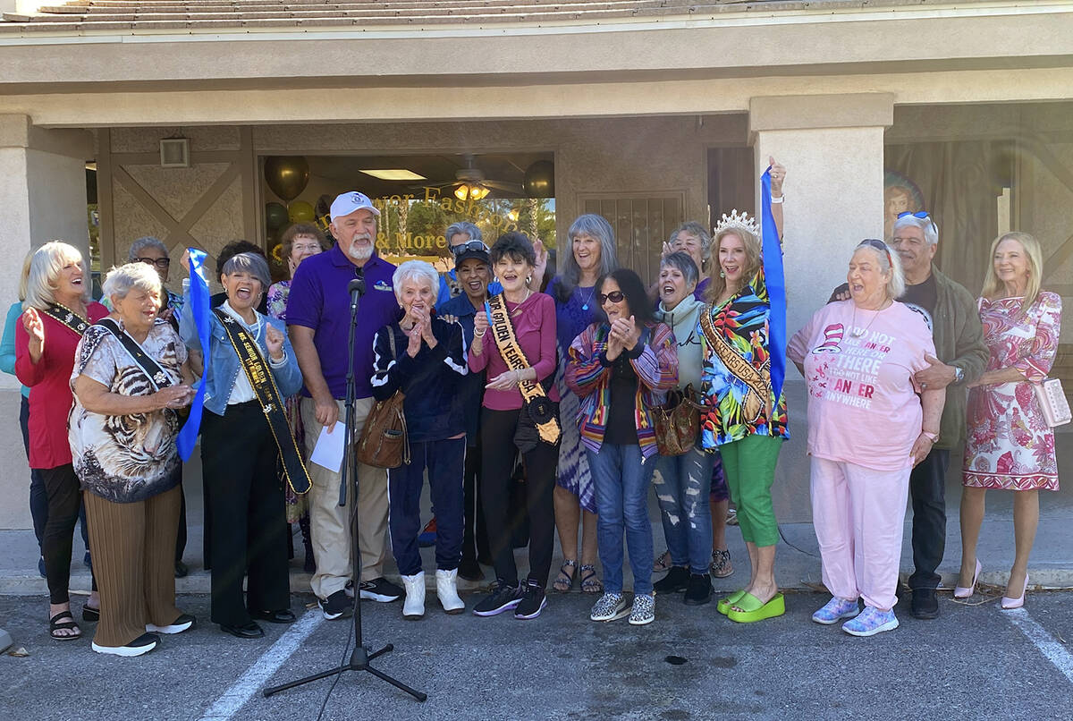 With a triumphant snip of the scissors, local shop owner Laraine Babbitt cuts the ribbon in cel ...