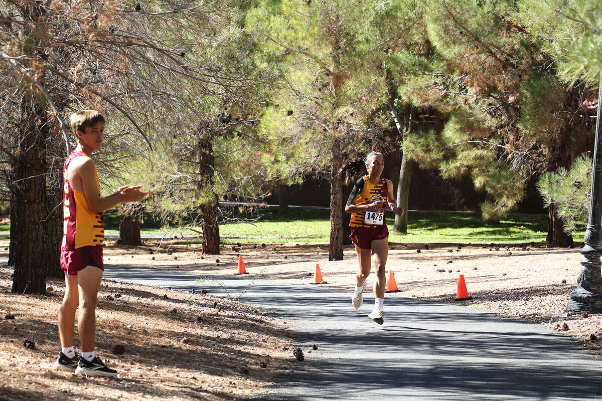 PVHS girls XC senior Julianna Ondrisko receives support near the end of the race from her teamm ...