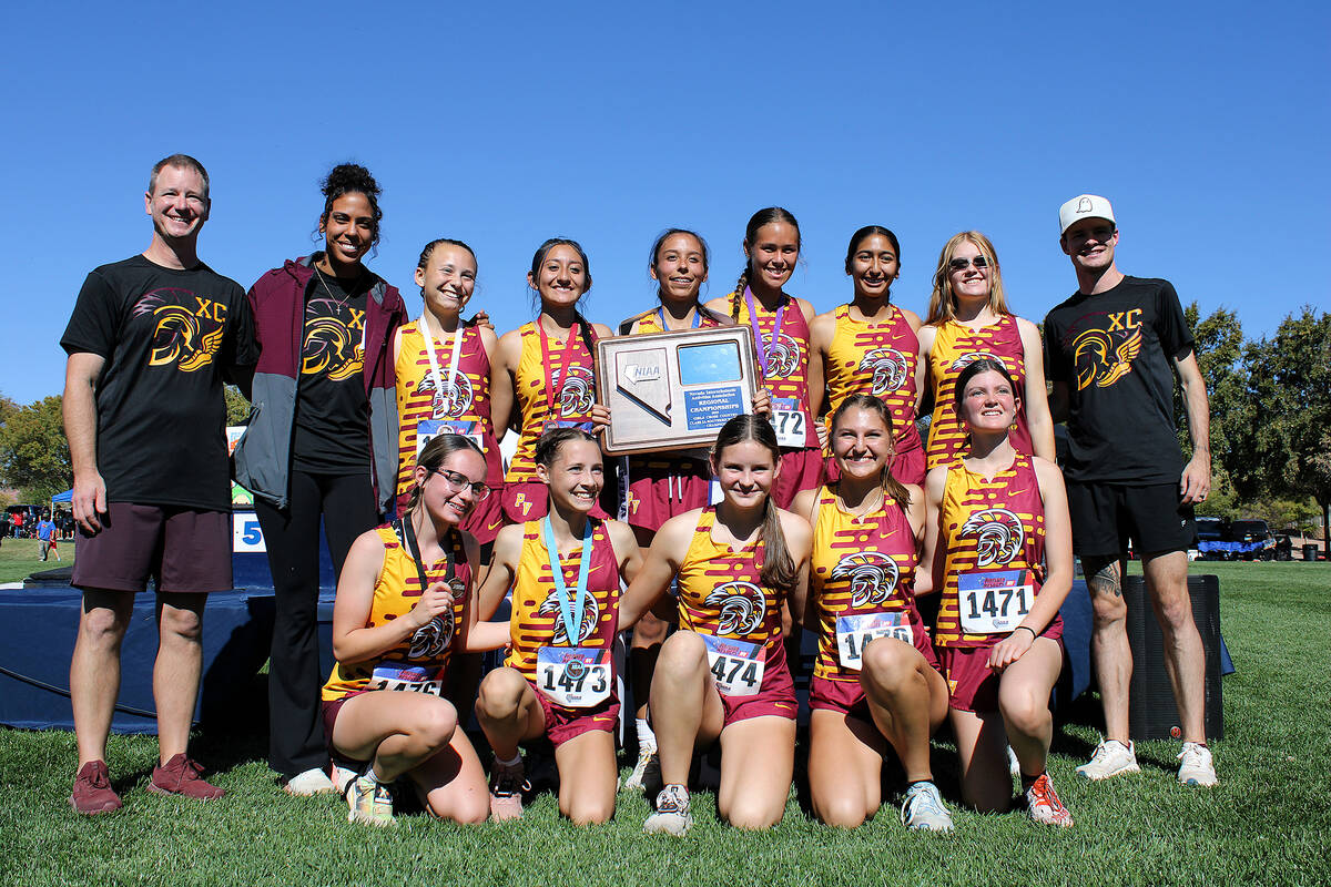 The Trojans girls XC team proudly holds up their newly earned hardware following the Class 3A S ...