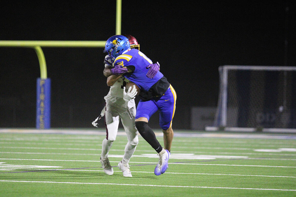 Moapa Valley High School senior wideout Jaxson Bunker tries to break a tackle against Pahrump V ...