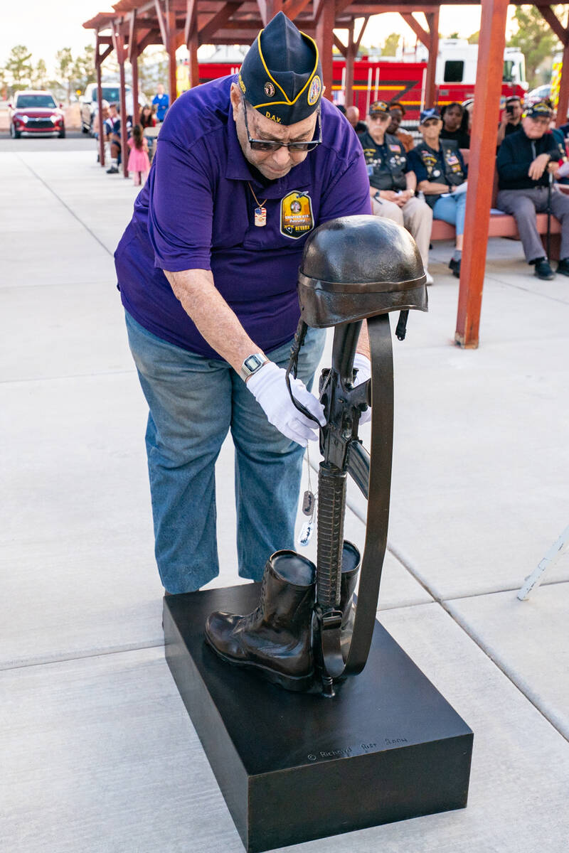 DAV member Richard Goldstein solemnly places ID/Dog Tags representing each branch of the U.S. m ...