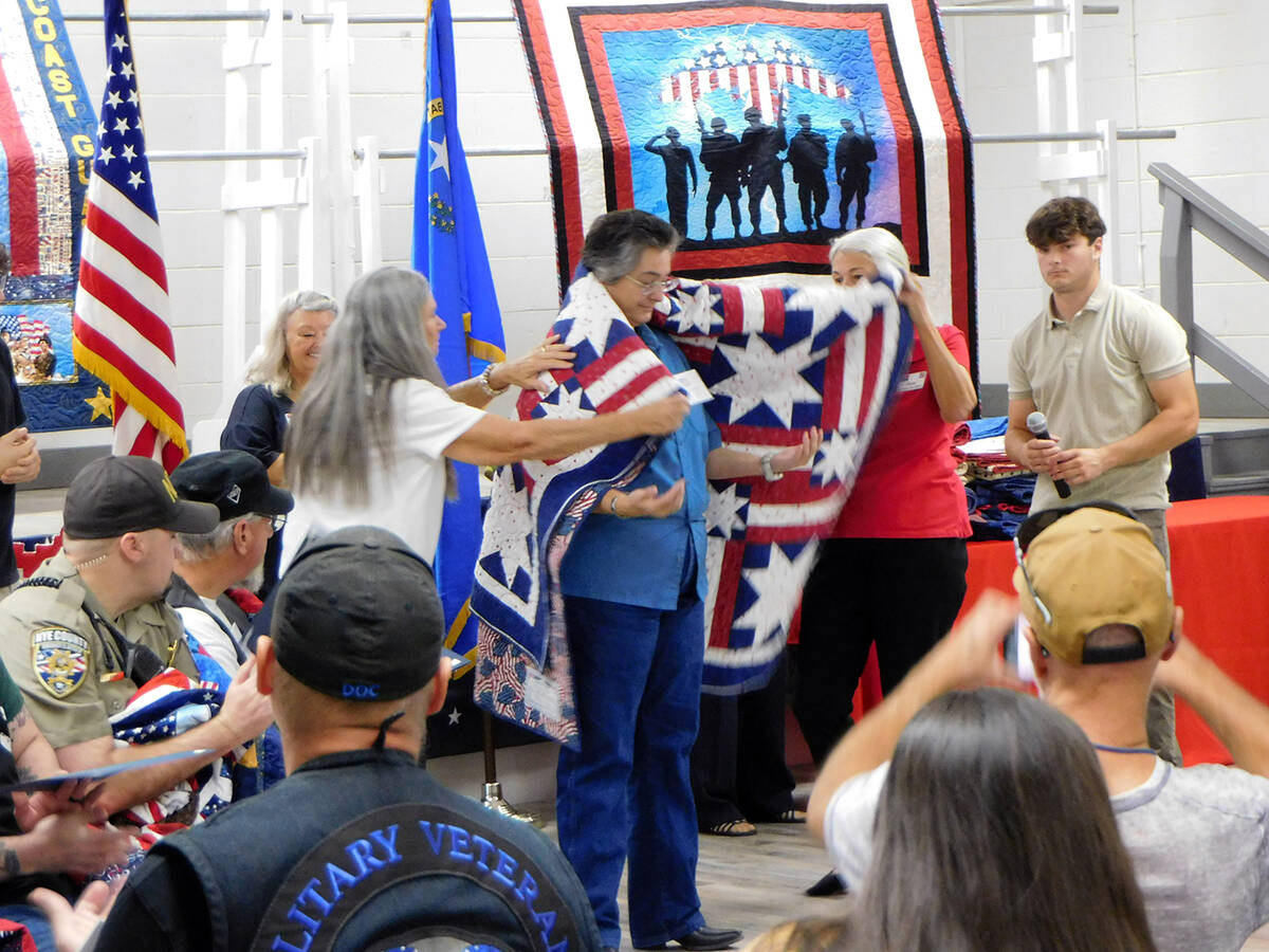 U.S. Army veteran Vicki Stephenson is wrapped in her brand new Quilt of Valor during the Nye Co ...