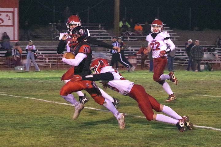 Tonopah High School junior Dustin Otteson sheds a Carlin defender as he makes his way toward th ...