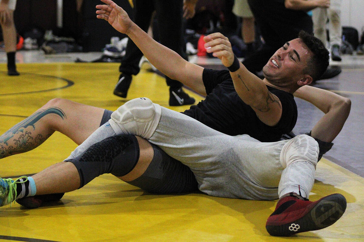 Pahrump Valley High School wrestling assistant coach Elliot Owens rolls with another student du ...