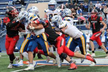 Pahranagat Valley High School senior Jesse Stewart rushes through multiple defenders in the Pan ...