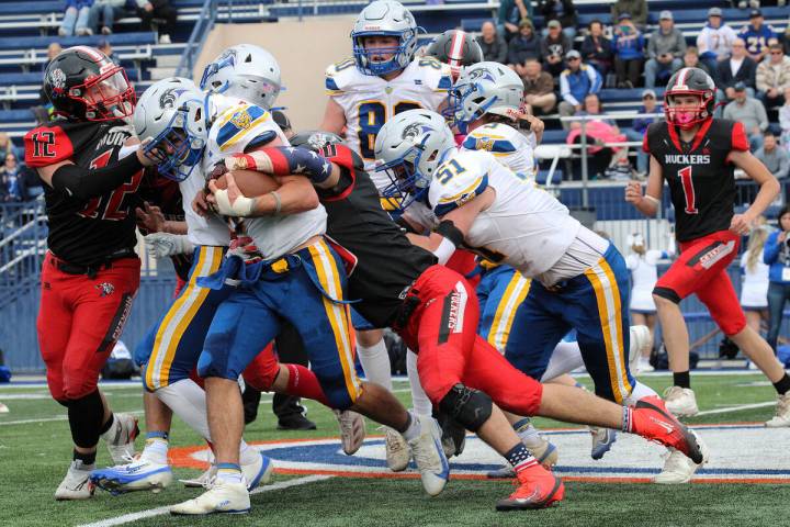 Pahranagat Valley High School senior Jesse Stewart rushes through multiple defenders in the Pan ...