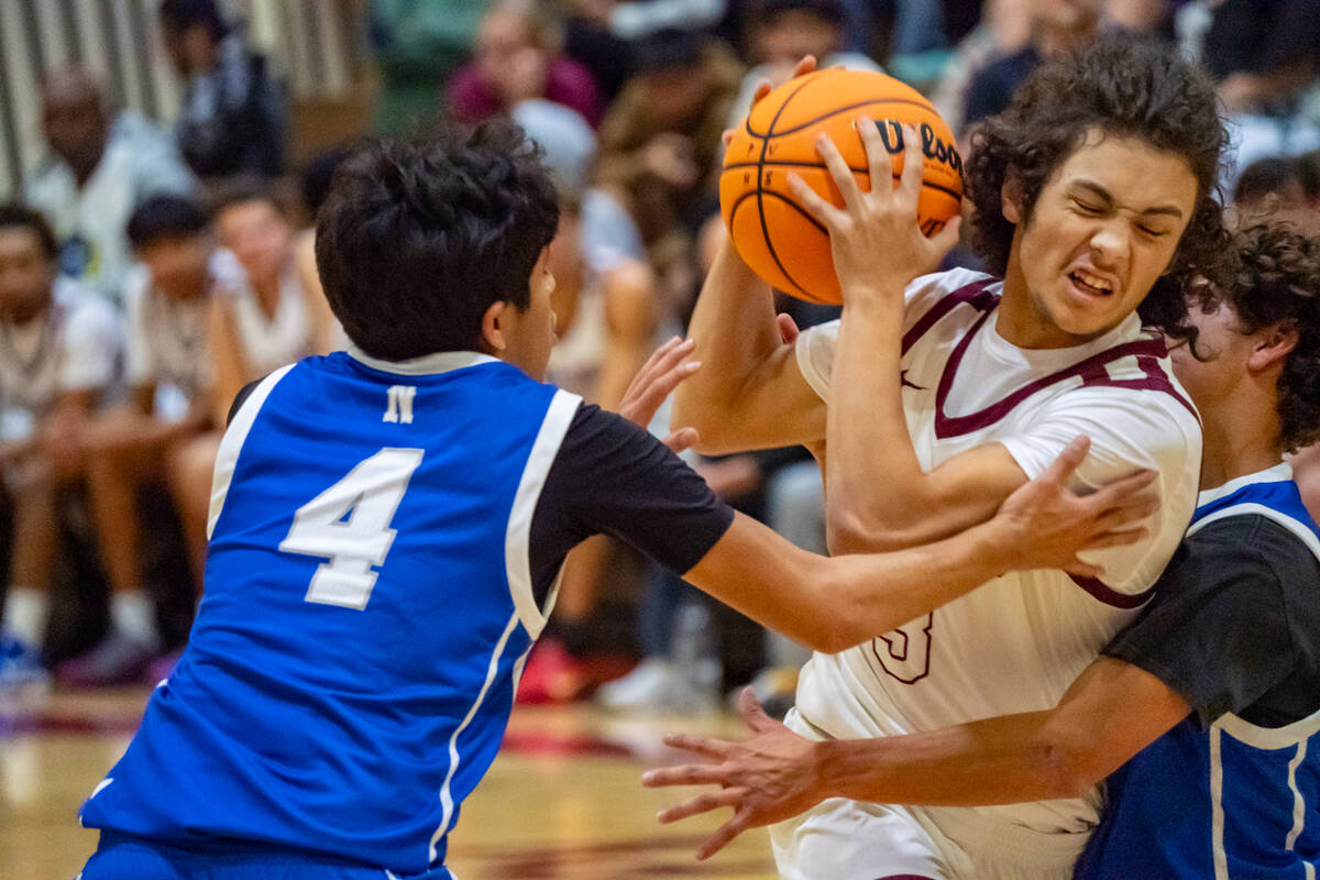Pahrump Valley High School senior guard Malachi Holland faces some stiff contact driving throug ...