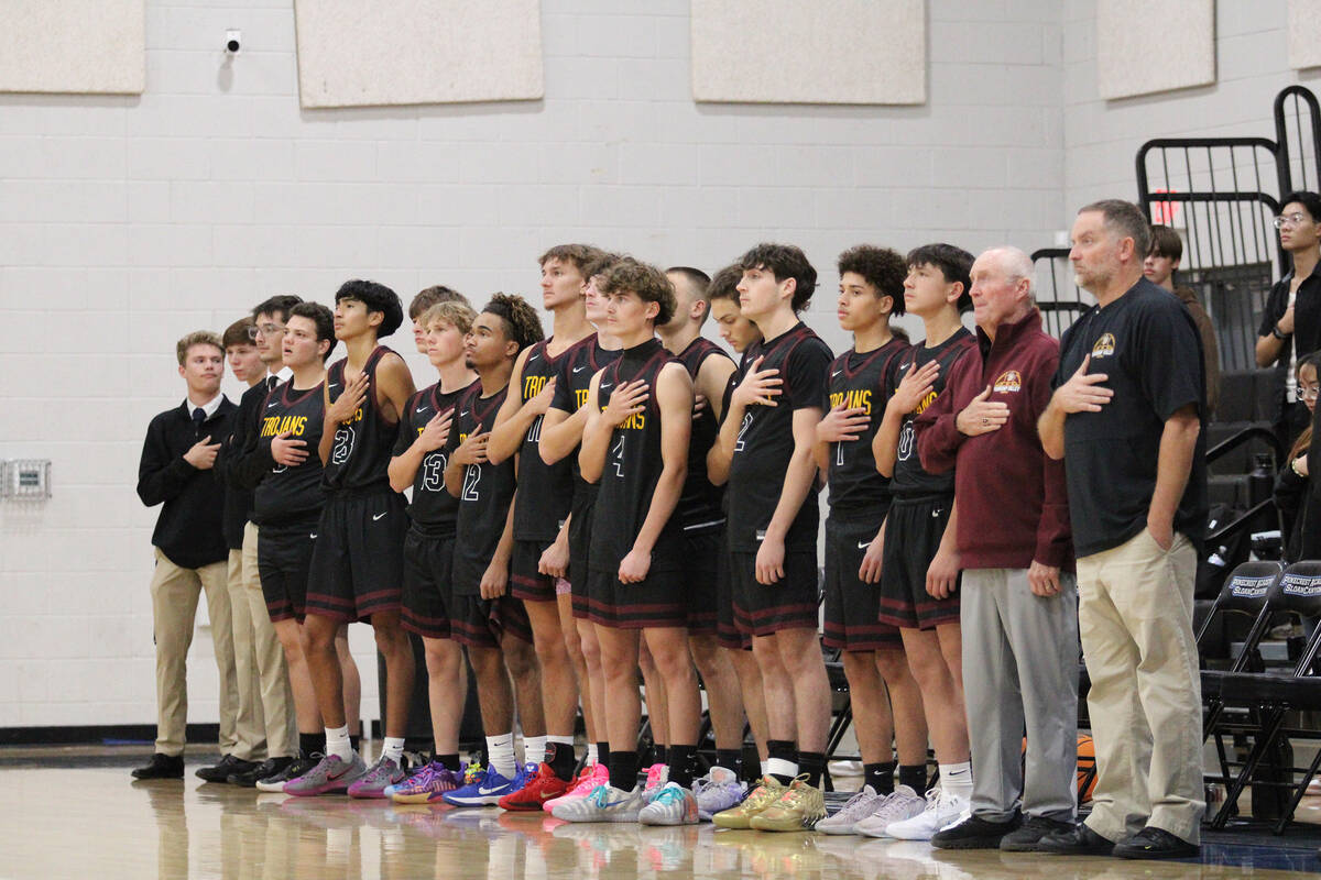 The Pahrump Valley High School varsity boys basketball team stands proudly for the National Ant ...