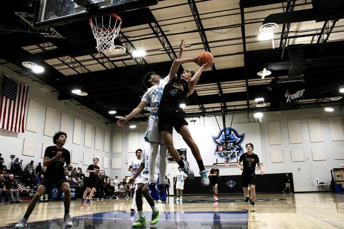 Pahrump Valley High School senior guard Kier Sheppard tries to avoid contact from Sloan Canyon ...