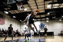Pahrump Valley High School senior guard Kier Sheppard tries to avoid contact from Sloan Canyon ...