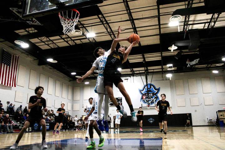 Pahrump Valley High School senior guard Kier Sheppard tries to avoid contact from Sloan Canyon ...