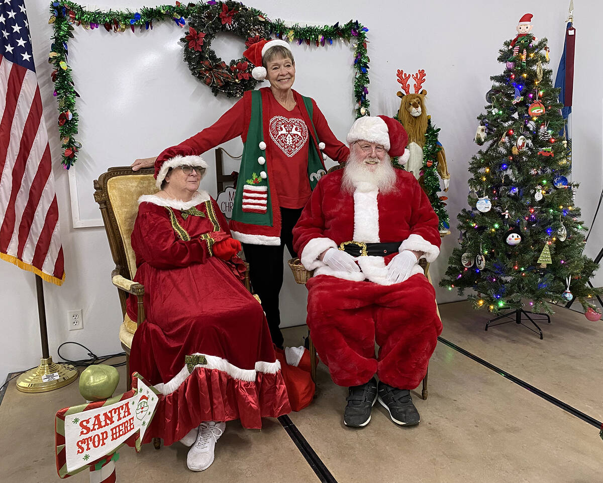 Pahrump Valley Lion Marcia Newyear poses with jolly old St. Nick and the missus at the club's B ...