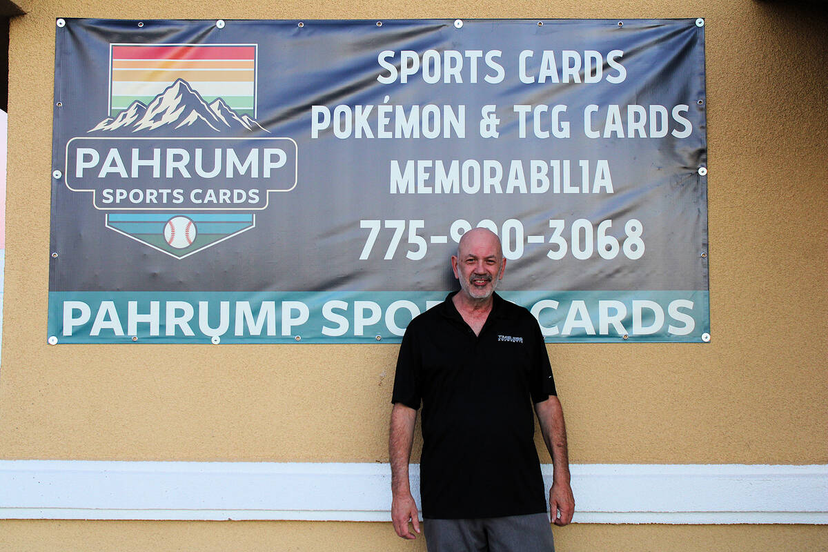 Pahrump Sports Cards shop owner Ernie Desaye proudly stands with his newly hung banner that he ...