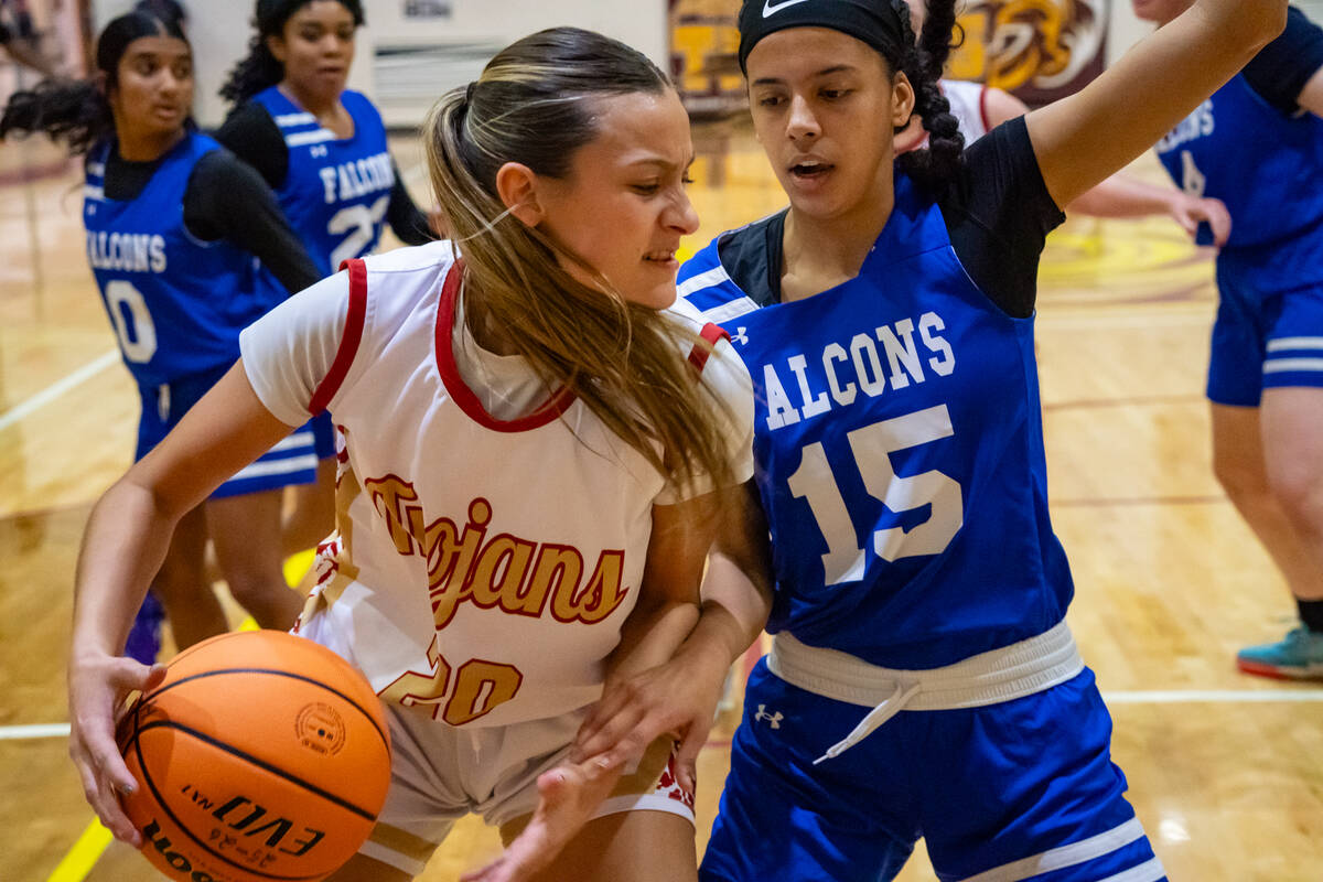Pahrump Valley High School junior Riley Saldana runs into hard contact in the paint during the ...