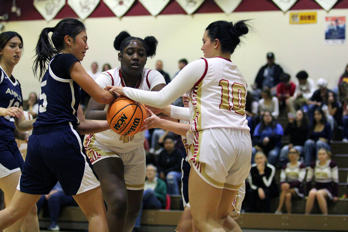 The Lady Trojans wrestle for possession as sophomores Adrian Rogers and Emily Zargoza do their ...