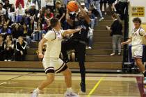 Pahrump Valley High School senior Joshua Slusher contends a shot from GV Christians senior guar ...