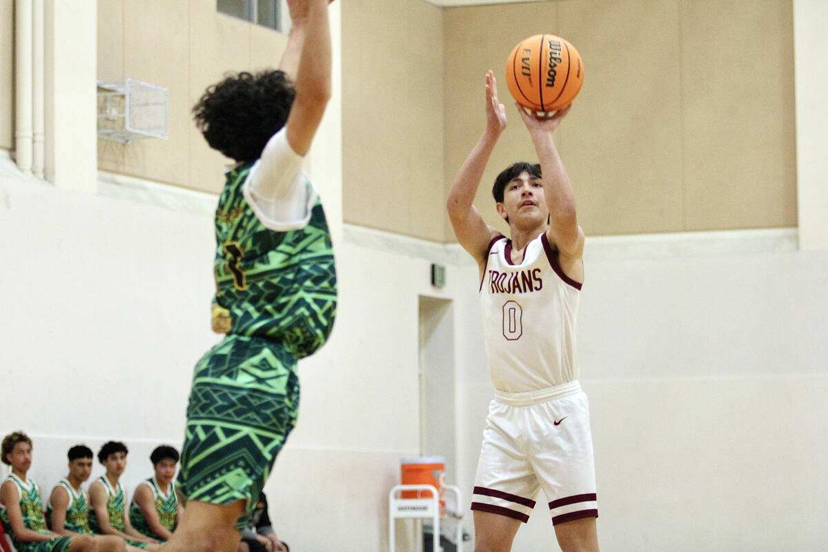 Pahrump Valley High School junior guard Levi Denton attempts a mid-range jumper during the Troj ...