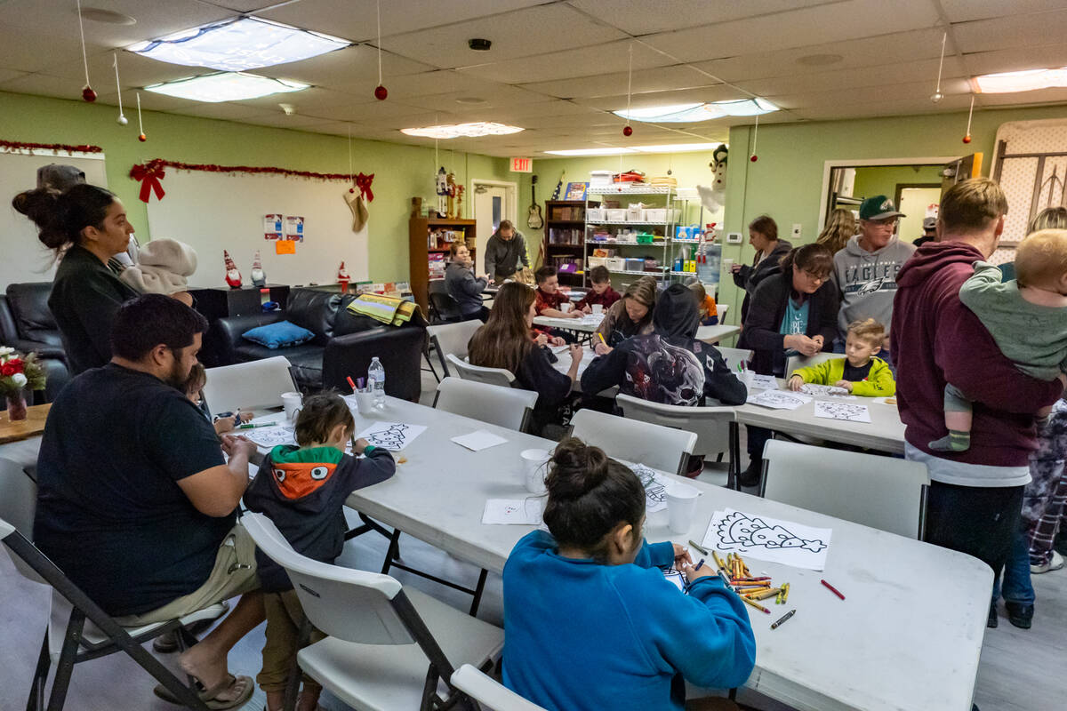 As families waited for their turn to meet and take photos with Santa, they were oﬀered hot co ...