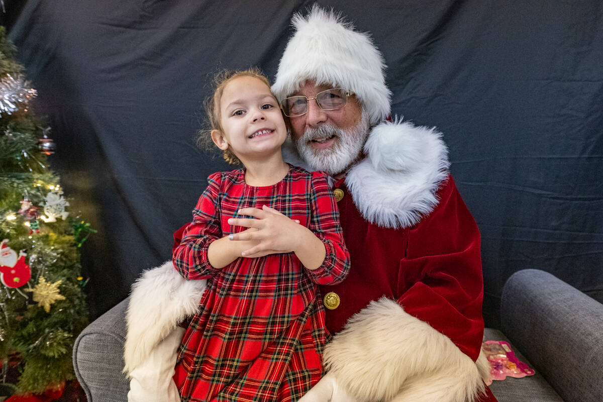 Janese Linear’s and Grant Butler’s daughter sits on Santa’s lap. (John Clausen/Pahrump Va ...