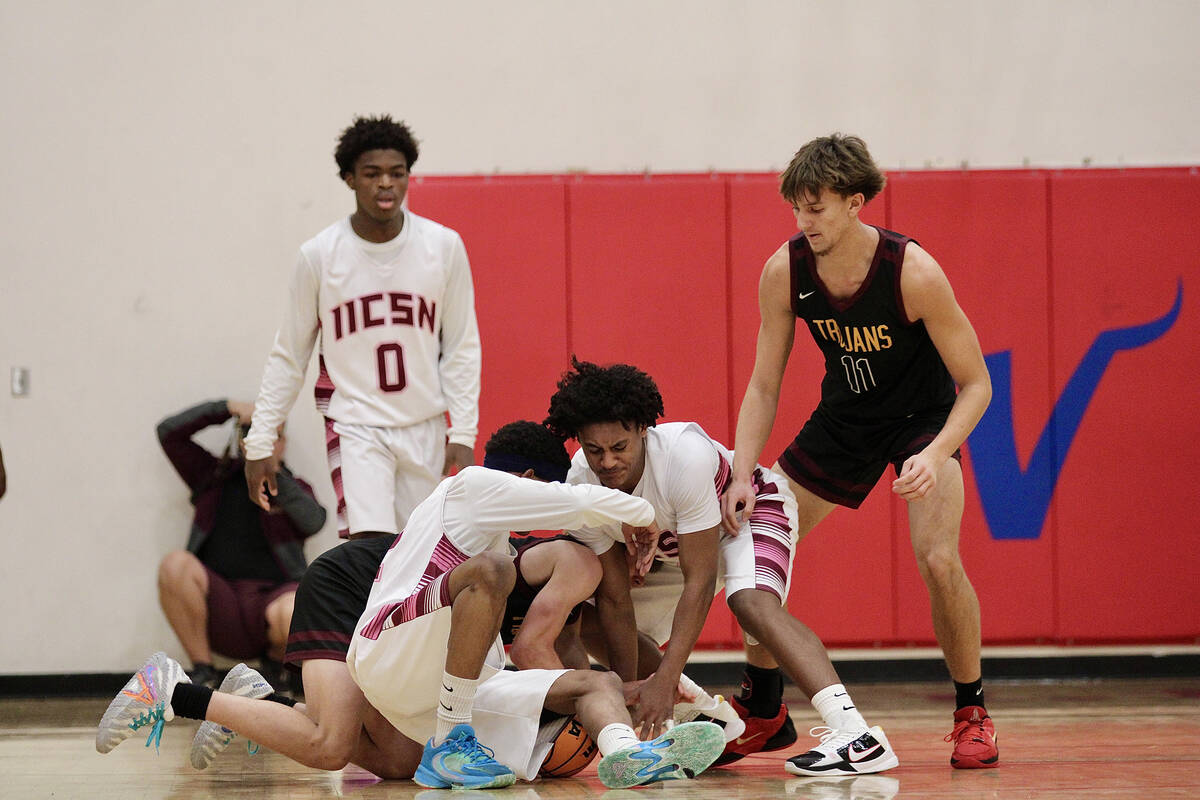 A scuffle for the ball down low ensues as Trojan center Aydon Veloz watched intently for the ba ...
